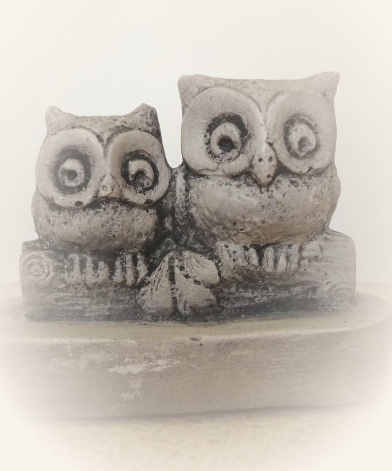 Deux petites chouettes en plâtre sur un socle